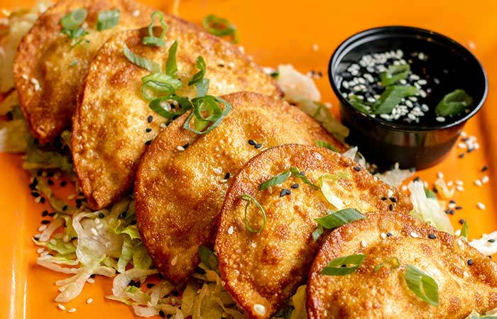 Featured on our restaurant menu Monticello MN: five crispy dumplings with green onions and sauce.