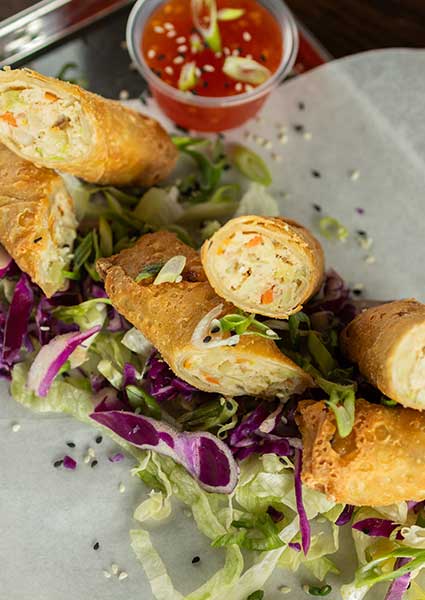 Egg rolls halved on cabbage with dipping sauce, served at a restaurant in Monticello MN.
