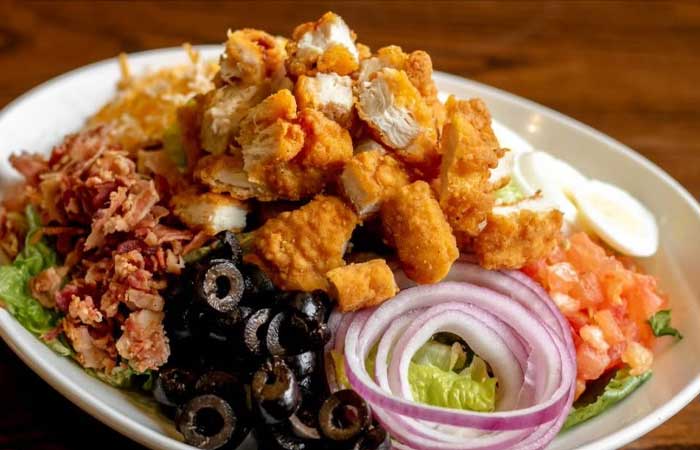 Featured on our restaurant menu in Monticello, MN: salad with fried chicken and fresh veggies.