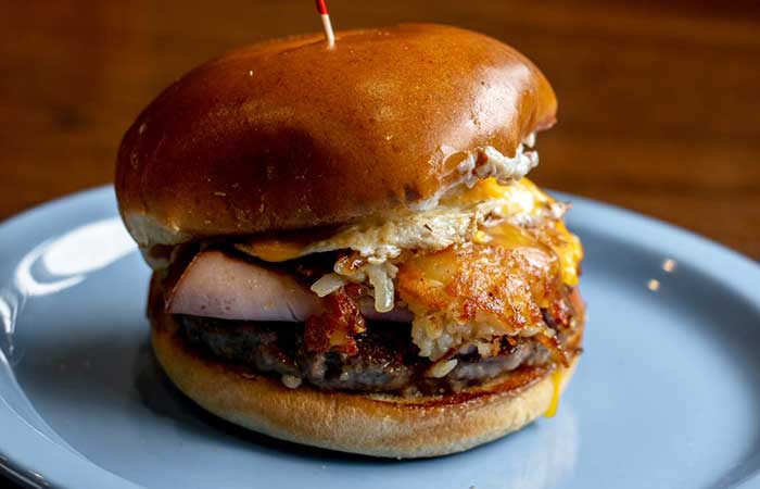 A cheeseburger with melted cheese, meat, and sauce on a bun features on our Monticello MN menu.