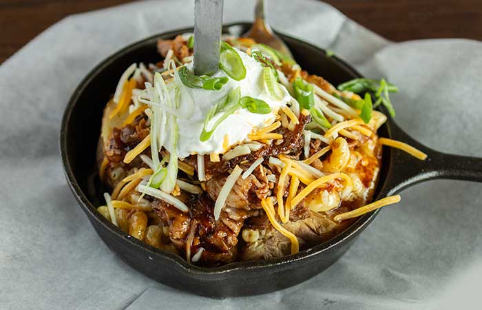 A restaurant menu Monticello MN favorite: fries topped with chili, cheese, sour cream, and onions.
