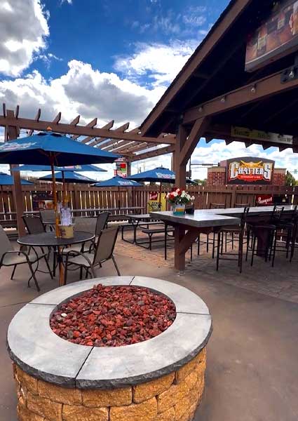 Outdoor patio at Chatters Restaurant & Bar Monticello featuring tables, umbrellas, and a fire pit.