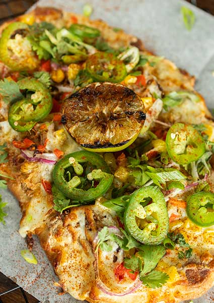 Flatbread pizza from our restaurant in Monticello MN, topped with cheese, jalapeños, and herbs.
