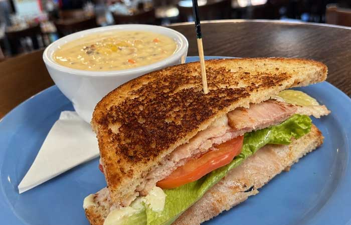 Enjoy Monticello restaurant food and drinks: grilled sandwich, fresh veggies, and creamy soup.
