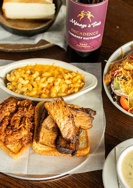 Brisket, pulled pork, mac and cheese, salad, and red wine at a restaurant in Monticello, MN.