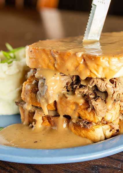 Hot roast beef sandwich covered in gravy with mashed potatoes at a restaurant in Monticello, MN.